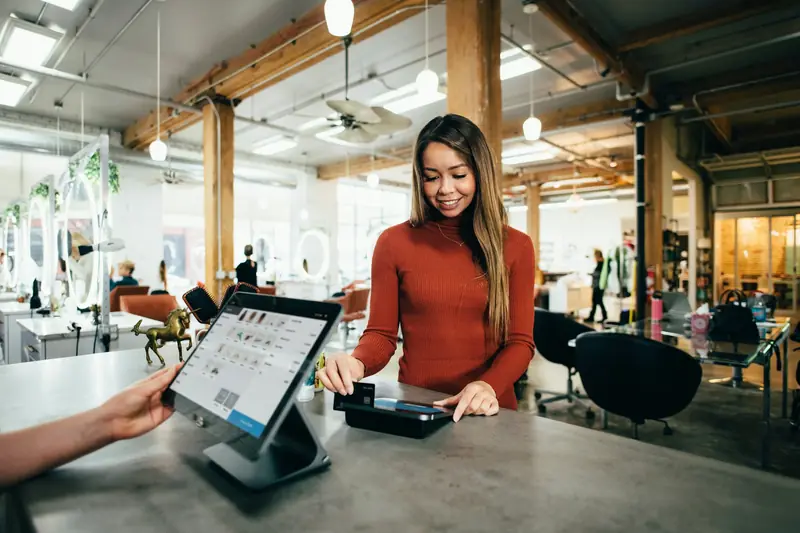 Commerçante qui encaisse sur une caisse tactile